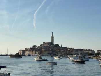Sailboats in city against sky