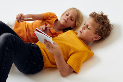 High angle view of sibling over white background