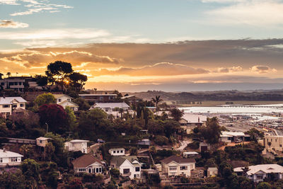 High angle view of townscape against cloudy sky at sunset