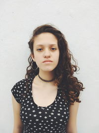 Portrait of young woman against wall