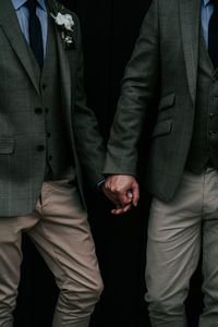 Midsection of gay couple holding hands