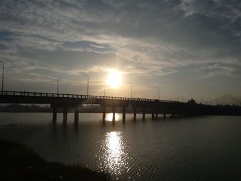 Bridge over river at sunset