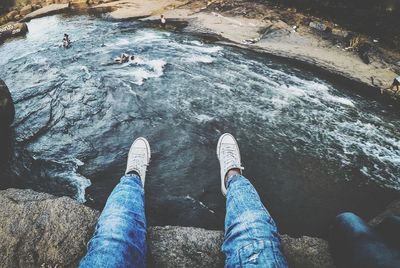 Low section of person on rock in sea