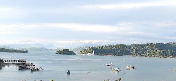 Sailboats in sea against sky