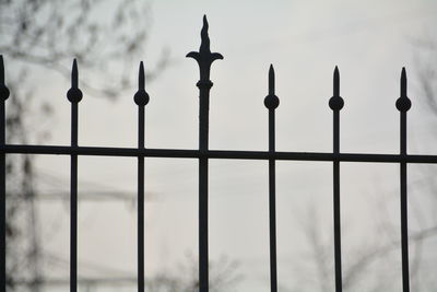 Close-up of metal railing against sky