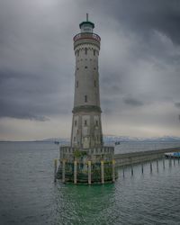 Lighthouse by sea against sky