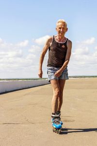 Full length portrait of man standing on sea shore against sky