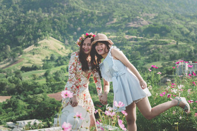 Happy woman standing by flowering plants