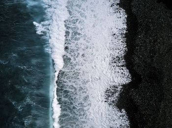 Directly above shots of waves at beach 