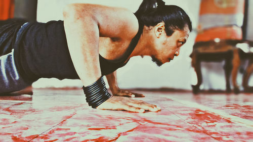 Side view of man doing push ups at gym