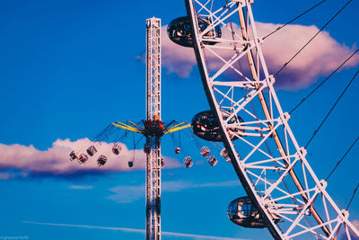 Low angle view of ferris wheel against blue sky