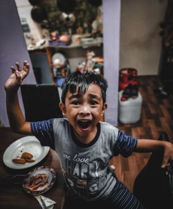 Portrait of a smiling boy on table at home