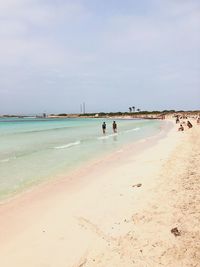 People on beach against sky