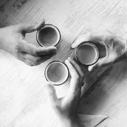 Close-up of hand holding coffee cup on table