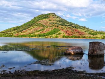 Scenic view of lake by mountains against sky