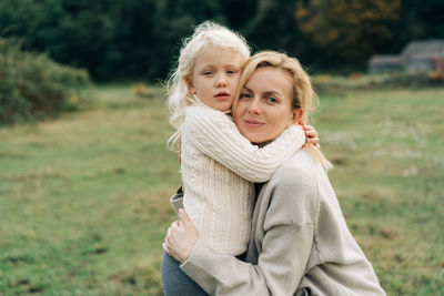 Mommy and little daughter hugging on a walk.