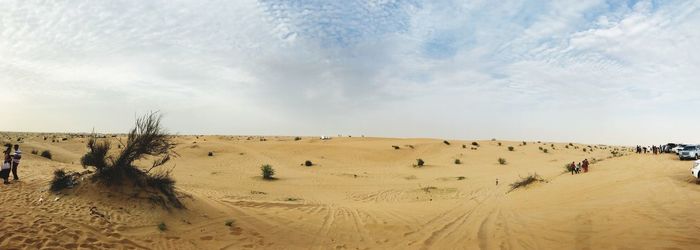 Panoramic view of sand dunes against sky