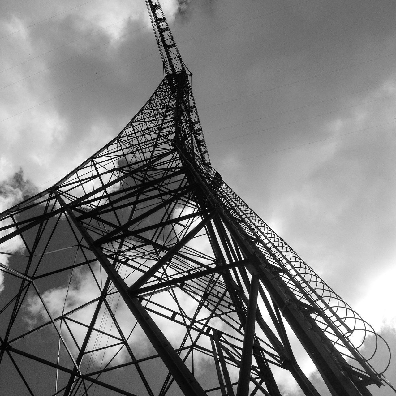 low angle view, sky, cloud - sky, metal, built structure, cloudy, cloud, metallic, tall - high, architecture, day, outdoors, no people, arts culture and entertainment, development, construction site, connection, tower, amusement park, crane - construction machinery