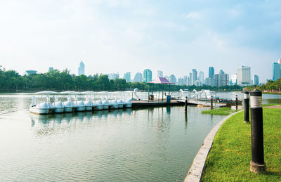 Boats moored in river with cityscape in background