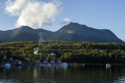 Scenic view of lake by mountains against sky
