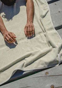 High angle view of man lying on towel at pier