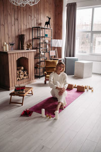 Woman sitting on wooden floor at home