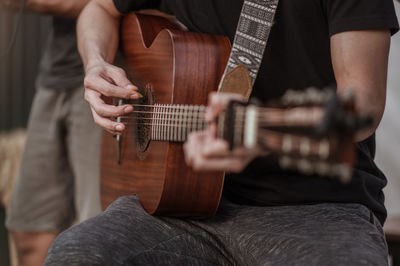 Cropped hand of guitarist playing guitar at music concert