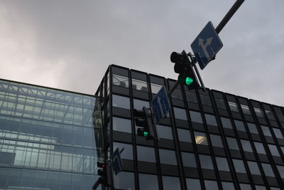 Low angle view of road signal against sky