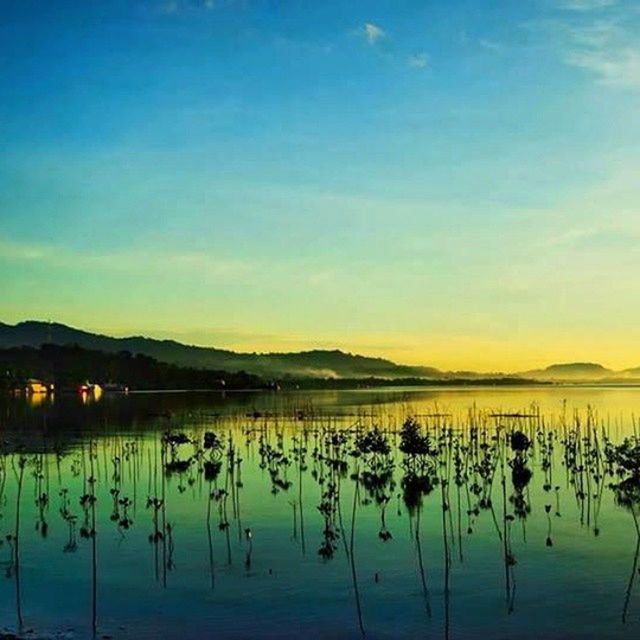 water, tranquil scene, tranquility, lake, scenics, sunset, mountain, beauty in nature, reflection, sky, mountain range, nature, idyllic, silhouette, calm, dusk, waterfront, outdoors, cloud, no people