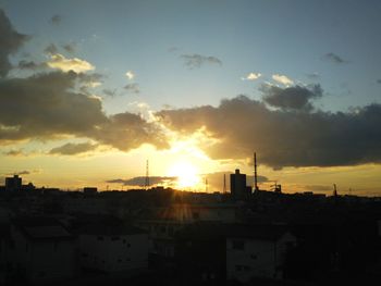 Silhouette cityscape against sky during sunset