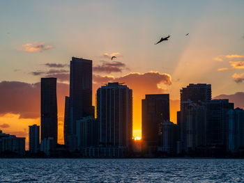 Skyscrapers in city at sunset