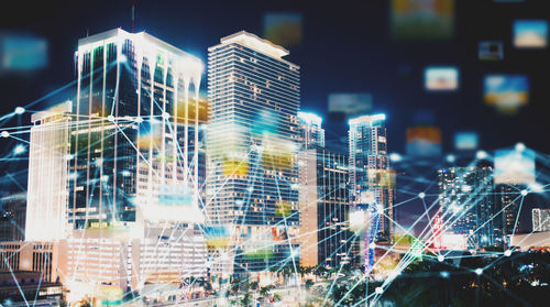 Digital composite image of illuminated modern buildings in city at night