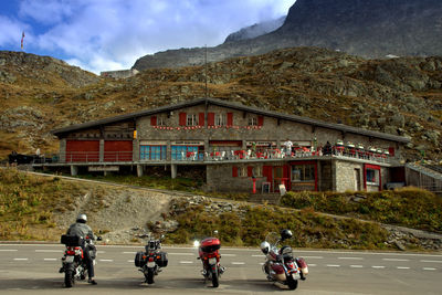 People riding motorcycle on road against sky