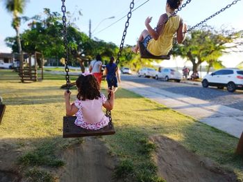 Children playing on swing at park