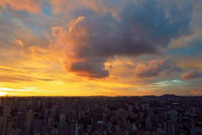 Panoramic view of buildings against dramatic sky during sunset