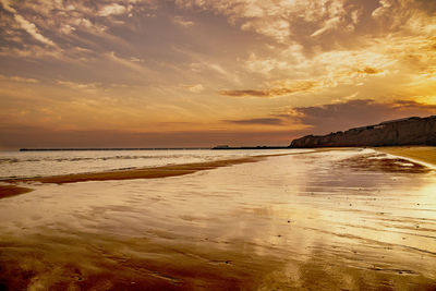 Scenic view of beach against sky during sunset