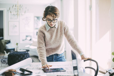 Woman reading on digital tablet working at home