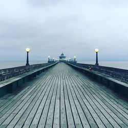 View of pier on sea against cloudy sky