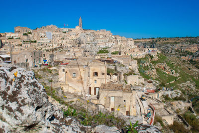 Buildings in city against clear blue sky