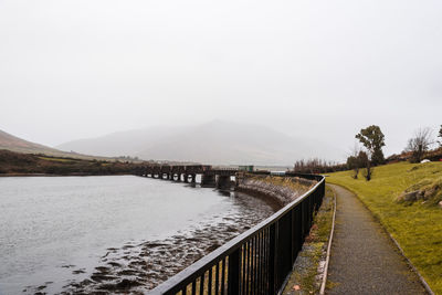 View of footbridge over river against sky