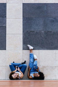 Rear view of two women lying on floor