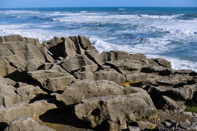 Scenic view of rocks on beach against sky