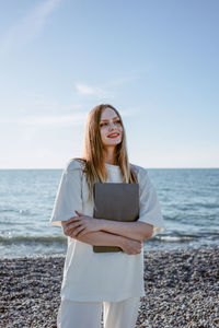 Portrait of young woman using mobile phone at beach