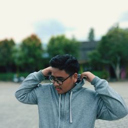 Portrait of young man standing against plants