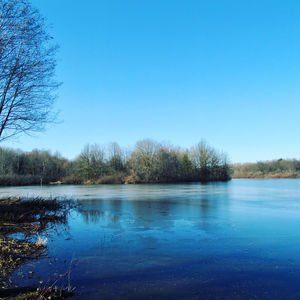 Scenic view of lake against clear blue sky