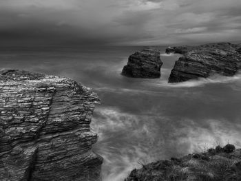 Rock formations in sea against sky