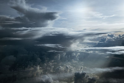 Low angle view of sunlight streaming through clouds