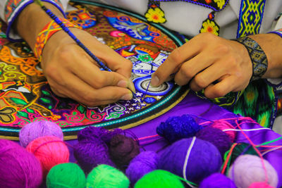 Cropped hands of person doing embroidery on textile