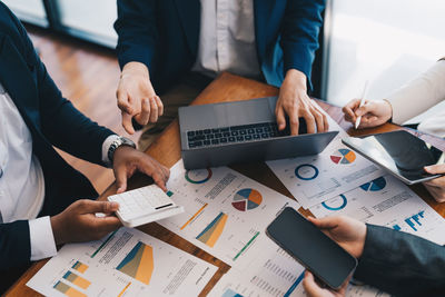 Midsection of business colleagues shaking hands in office