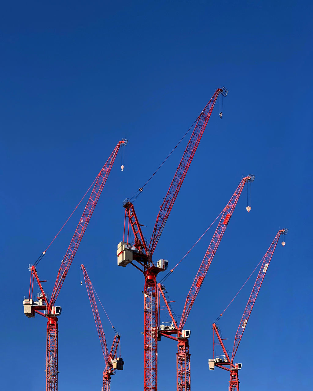 machinery, crane - construction machinery, blue, construction industry, sky, industry, construction site, clear sky, development, no people, day, nature, low angle view, metal, tall - high, copy space, outdoors, construction equipment, construction machinery, sunlight, industrial equipment